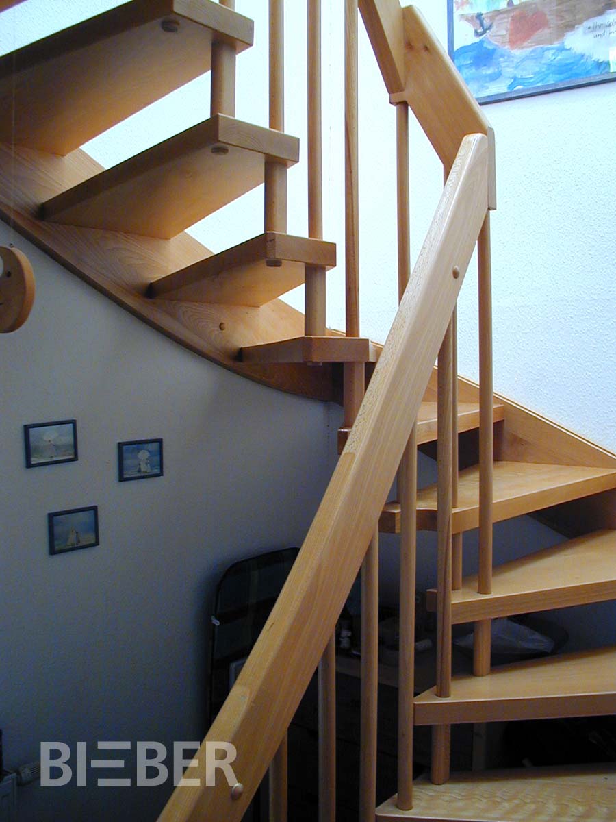 Halbgewendelte Treppe in Esche Massivholz, Wandseite eingestemmte Wange, Lichtseite verbolzt, Geländer Rundstäbe