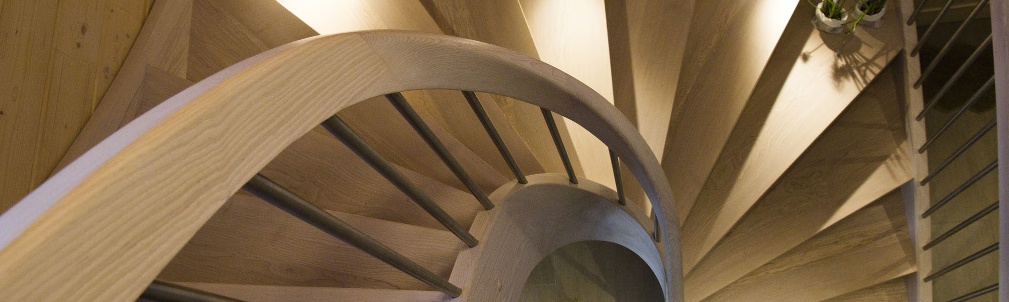 Treppe Massivholz Esche, halbgewendelt mit Setzstufen, Wangen- und Geländerkrümmling, gebeizt mit Ölbeize, Edelstahlgeländer