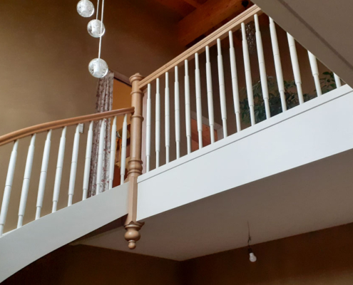 Holztreppe Eiche halbgewendelt mit weißen Wangen und Krümmlingen, gedrechseltes Geländer & Galerie